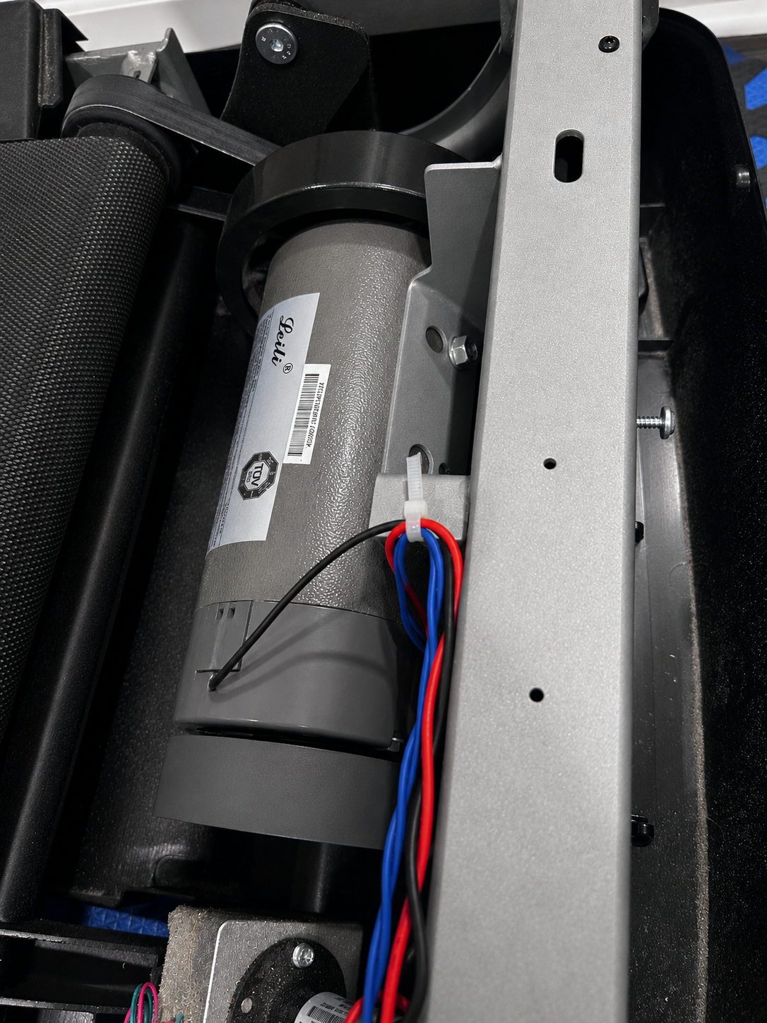 Technician repairing treadmill components.